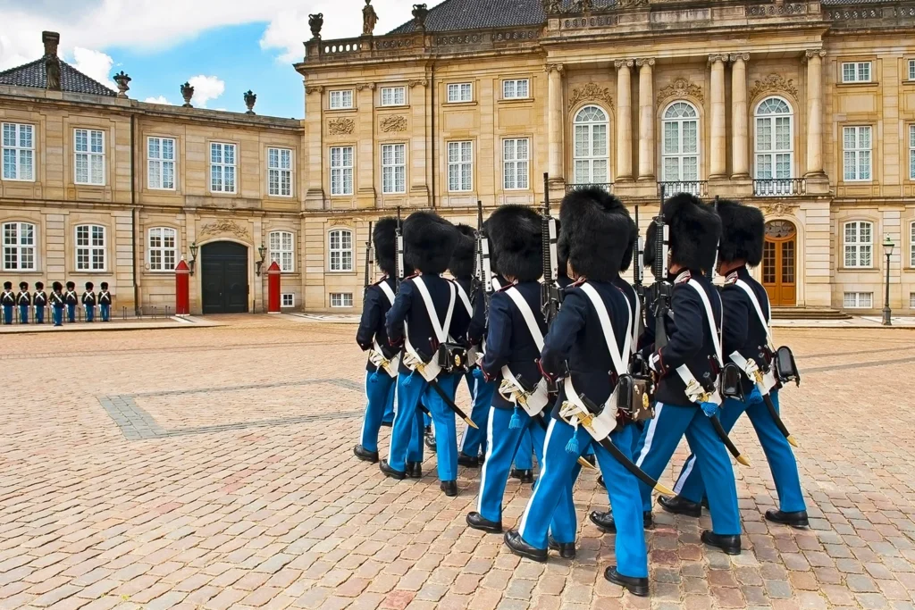 Royal guards in distinctive uniforms stand in front of each palace.